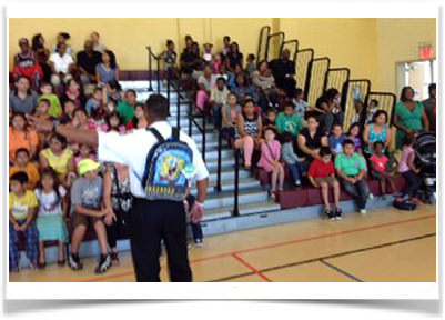 Captain Willie Bailey distributes backpacks to kids.